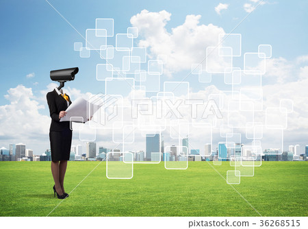 Camera headed woman standing on green grass against modern cityscape Camera headed woman standing on green grass against modern cityscape 36268515