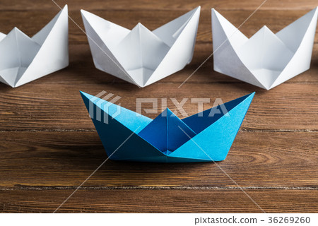 Business leadership concept with white and color paper boats on wooden table 36269260