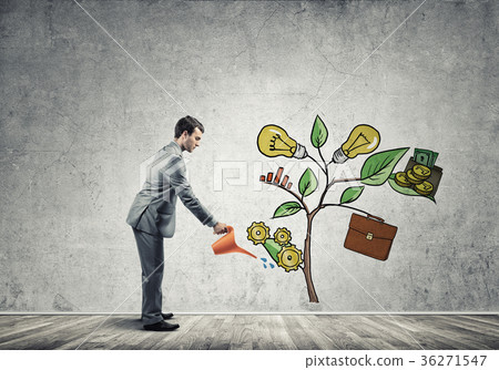 Young businessman in empty room watering drawn growth concept with can 36271547