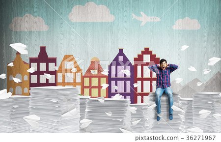 Young man sitting on pile of paper documents. Young man sitting on pile of paper documents. 36271967