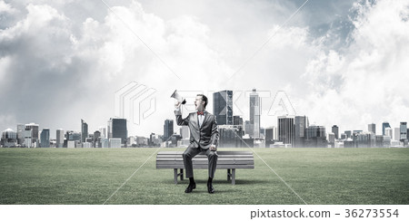 Businessman in summer park announcing something in loudspeaker a Businessman in summer park announcing something in loudspeaker a 36273554