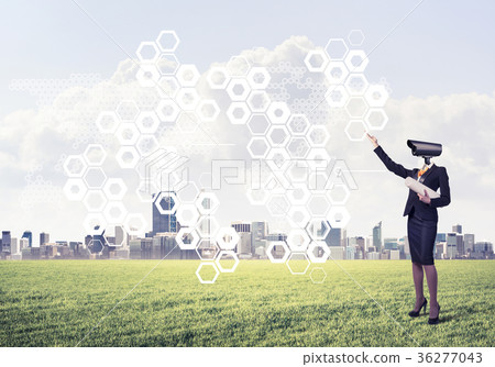 Camera headed woman standing on green grass against modern citys Camera headed woman standing on green grass against modern citys 36277043