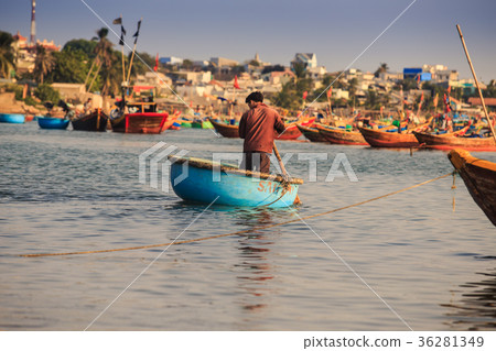 View Guy Rows in Round Fishing Boat in Calm Sea 36281349