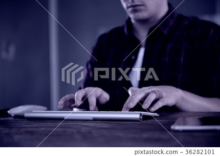 A young man working on a computer in their home. 36282101
