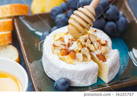Brie cheese (camembert) with honey, nuts, baguette 36283787