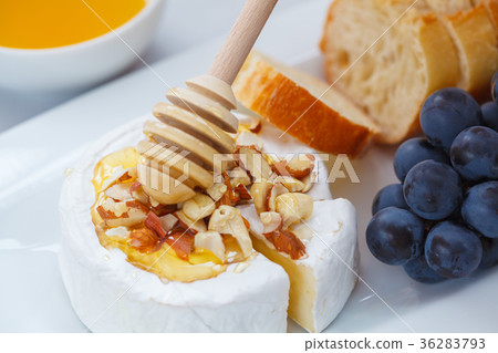 Brie cheese (camembert) with honey, nuts, baguette Brie cheese (camembert) with honey, nuts, baguette 36283793