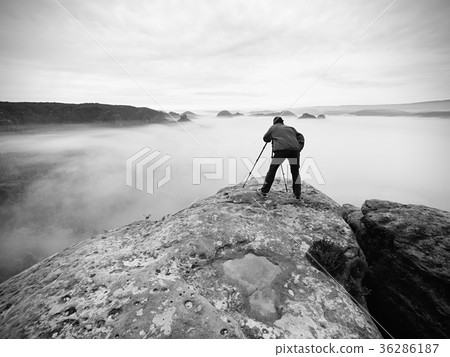 Photographer on crater. Man on peak above cloud, Photographer on crater. Man on peak above cloud, 36286187