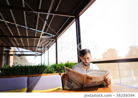 Handsome male person reading newspaper and Handsome male person reading newspaper and 36289394