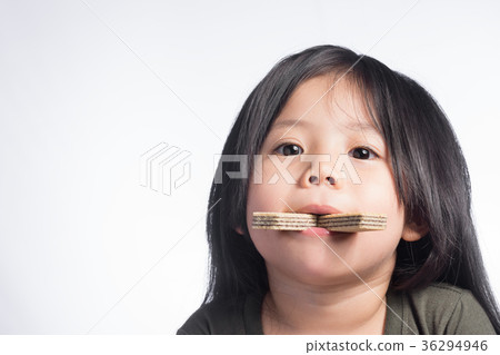 Portraits a Little Cute Thailand Girl and wafer in the mouth. Portraits a Little Cute Thailand Girl and wafer in the mouth. 36294946