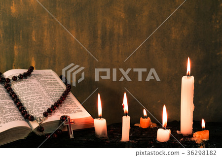Bible and candle on an old wooden burnt table. Bea Bible and candle on an old wooden burnt table. Bea 36298182