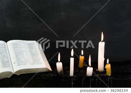 Bible and candle on an old wooden burnt table 36298334
