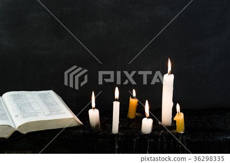 Bible and candle on an old wooden burnt table Bible and candle on an old wooden burnt table 36298335