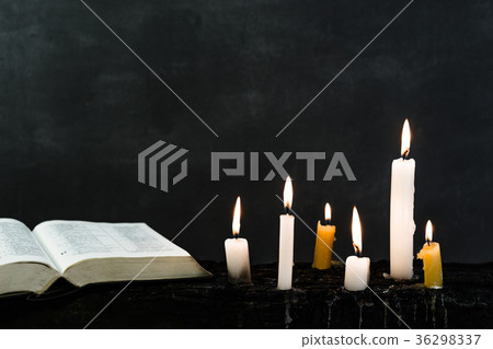 Bible and candle on an old wooden burnt table 36298337