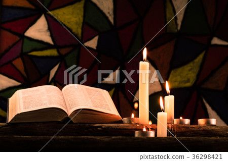 Bible and candle on a old oak wooden table.  36298421