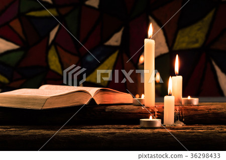 Bible and candle on a old oak wooden table. Bible and candle on a old oak wooden table. 36298433
