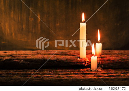 Bible and candle on a old oak wooden table. Bible and candle on a old oak wooden table. 36298472