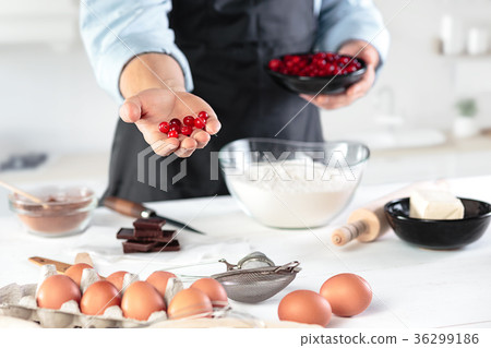 A cook with eggs on a rustic kitchen against the 36299186