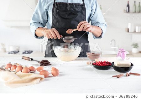A cook with eggs on a rustic kitchen against the A cook with eggs on a rustic kitchen against the 36299246