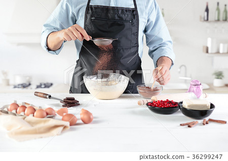 A cook with eggs on a rustic kitchen against the A cook with eggs on a rustic kitchen against the 36299247