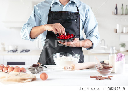 A cook with eggs on a rustic kitchen against the 36299249