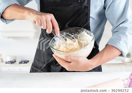 A cook with eggs on a rustic kitchen against the A cook with eggs on a rustic kitchen against the 36299252