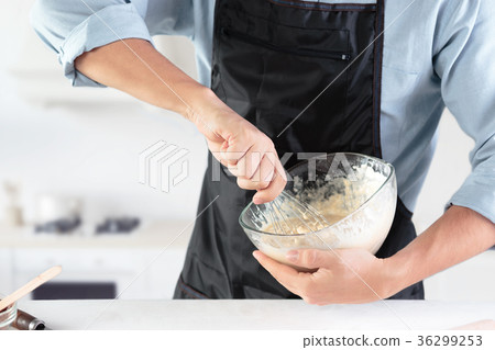 A cook with eggs on a rustic kitchen against the A cook with eggs on a rustic kitchen against the 36299253
