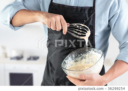 A cook with eggs on a rustic kitchen against the A cook with eggs on a rustic kitchen against the 36299254