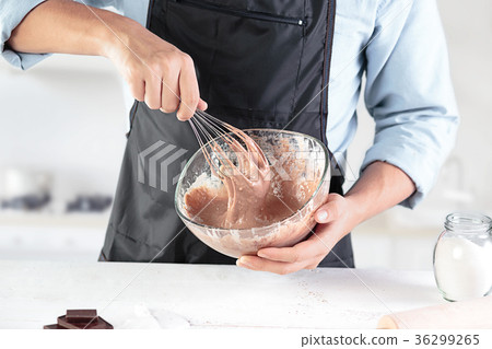 A cook with eggs on a rustic kitchen against the 36299265