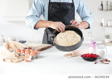 A cook with eggs on a rustic kitchen against the A cook with eggs on a rustic kitchen against the 36299284