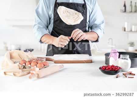 A cook with eggs on a rustic kitchen against the 36299287