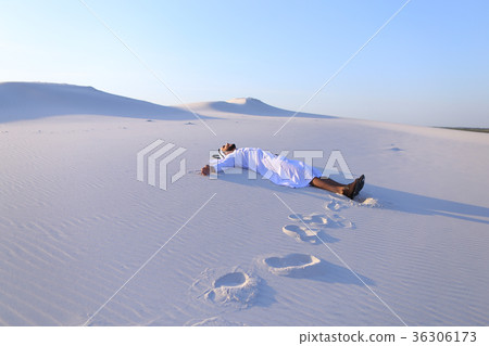 Happy male Arab lies along white sand desert and Happy male Arab lies along white sand desert and 36306173