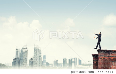 Danger and risk concept with businessman making step from edge 36306344