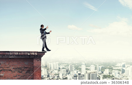 Danger and risk concept with businessman making step from edge 36306348