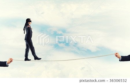 Business concept of risk support and assistance with man balancing on rope Business concept of risk support and assistance with man balancing on rope 36306532