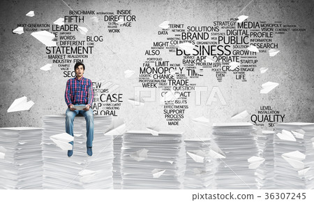 Attractive man sitting on pile of paper documents. Attractive man sitting on pile of paper documents. 36307245