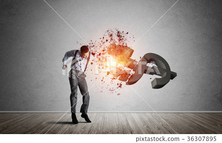 Determined banker man in empty concrete room breaking dollar figure Determined banker man in empty concrete room breaking dollar figure 36307895