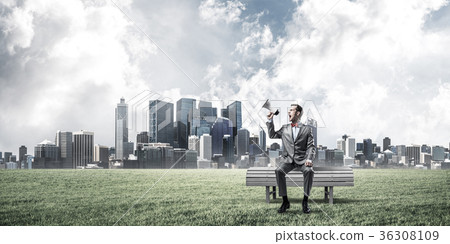 Businessman in summer park announcing something in loudspeaker a Businessman in summer park announcing something in loudspeaker a 36308109