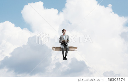 Young businessman or student floating in blue sky and studying the science Young businessman or student floating in blue sky and studying the science 36308574