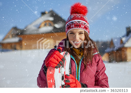Sporty female holds snowboard in mountains Sporty female holds snowboard in mountains 36320313