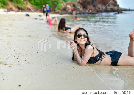 Beautiful woman wearing a swimsuit playing in the beach. 36325046