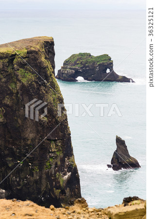 rocks in ocean and on Dyrholaey cliff in Iceland 36325121