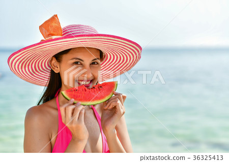 Beautiful girl wearing swimsuit eating watermelon beach. 36325413