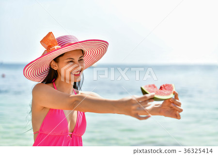 Beautiful girl wearing swimsuit eating watermelon beach. 36325414