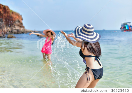 Beautiful woman wearing a swimsuit playing in the beach. Beautiful woman wearing a swimsuit playing in the beach. 36325420