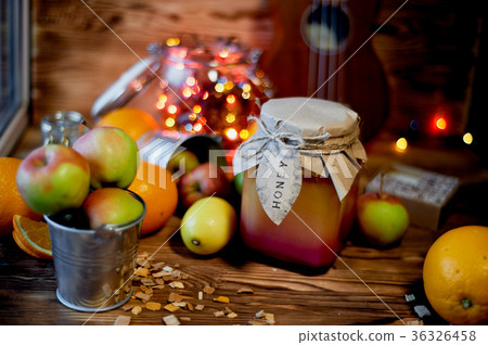 A jar of honey in the middle of citrus, lit A jar of honey in the middle of citrus, lit 36326458