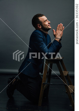 young businessman prays to the knees beside a 36335302