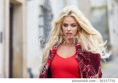 Young smiling blonde hair woman on the city streets on sunny day Young smiling blonde hair woman on the city streets on sunny day 36337750