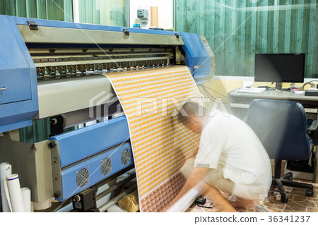 Technician roll up sticker business card banner during printing 36341237