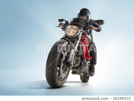 Biker in black jacket and helmet sitting on his Biker in black jacket and helmet sitting on his 36349332