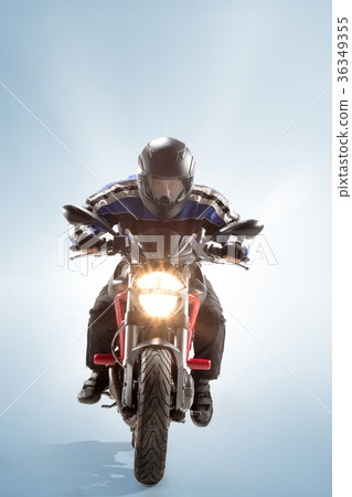 Biker in black jacket and helmet sitting on his 36349355